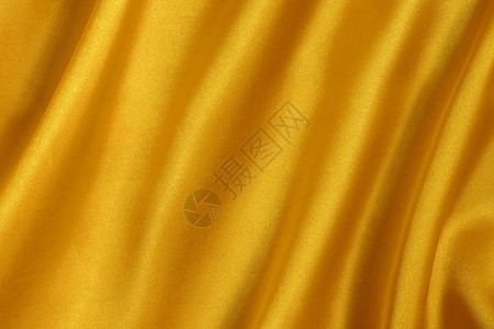 优雅和光滑的金色西边背景丝绸折叠窗帘衣服纺织品床单织物海浪版税布料图片