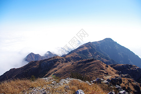 彩云环绕着中国的中华人Xizang山脊登山山腰高地悬崖天空杂草顶峰亮度山沟空洞图片