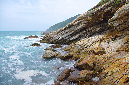 南中华南部美丽的海边岩石海岸线远景山麓天气季节海浪蓝色海水天空海滩图片