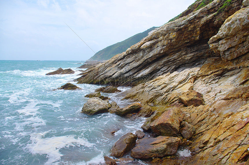 南中华南部美丽的海边岩石海岸线远景山麓天气季节海浪蓝色海水天空海滩图片