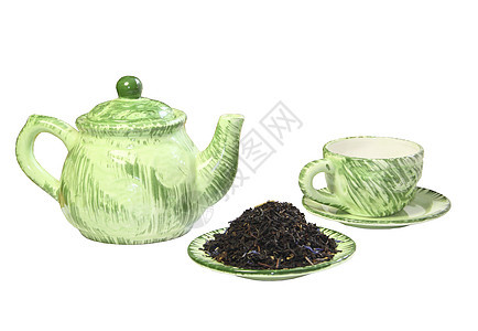 绿色茶壶 杯子和碟上黑茶图片