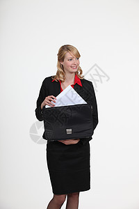 将文件放在公文包中的高级金发女商务人士图片