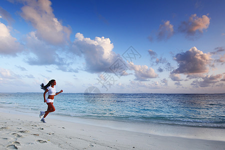 女人在海滩上奔跑运动装运动员女孩天空海洋黑发赛跑者日落女性成人图片