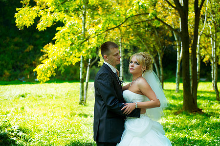 绿色公园背景的新娘和新郎女士幸福丈夫裙子婚姻男性夫妻花束庆典套装图片
