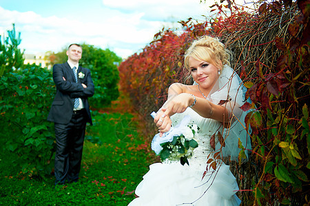 绿色公园背景的新娘和新郎拥抱庆典套装裙子妻子女性男人夫妻婚礼女士图片