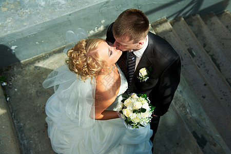 楼梯背景上的新娘和新郎女性婚礼拥抱微笑场地男人幸福男性裙子花束图片