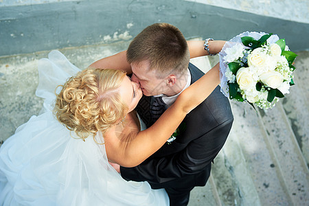 楼梯背景上的新娘和新郎拥抱妻子微笑幸福套装丈夫夫妻男性场地女士图片