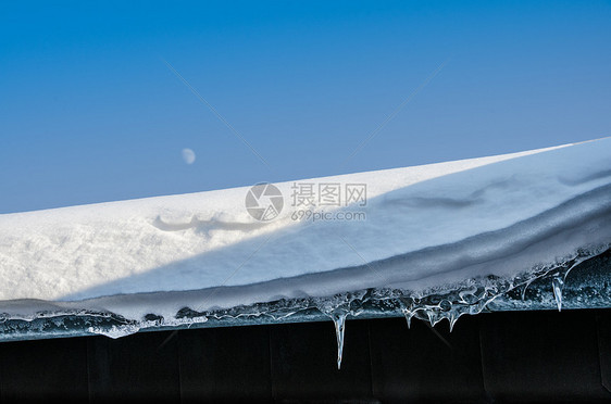 蓝色天空的雪屋顶图片