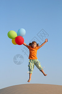 快乐的小女孩 用气球跳跃跑步场地娱乐孩子乐趣女性童年白色海滩图片