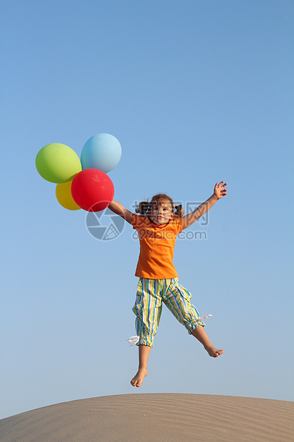 快乐的小女孩 用气球跳跃跑步场地娱乐孩子乐趣女性童年白色海滩图片