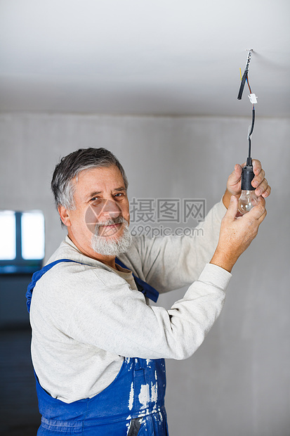 年长者在新装修的公寓内安装灯泡现代化维修翻拍工艺男人改装整容检修工匠改造图片