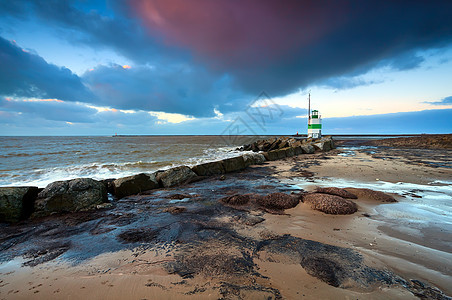 日落时北海的灯塔海滩粉色旅行海浪绿色太阳海岸戏剧性红色信号图片