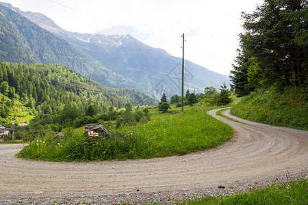 瑞士阿尔卑斯山的一条乡村公路草地天空岩石旅行国家绿色踪迹农村小路森林图片