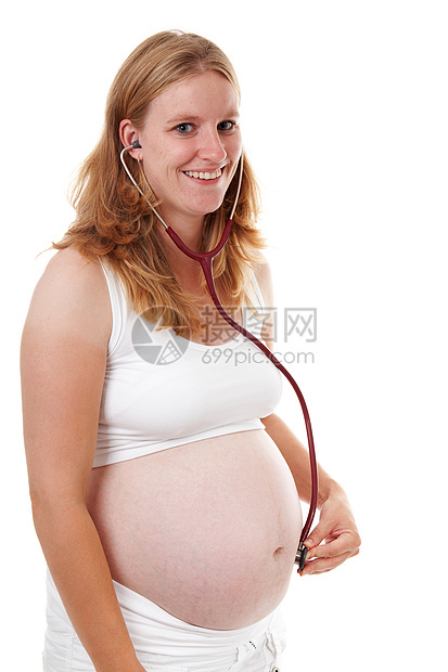 母亲在孕妇肚子上用听诊器监听图片