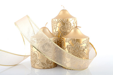 三根金蜡烛和鞠躬宗教丝带装饰品金子背景图片