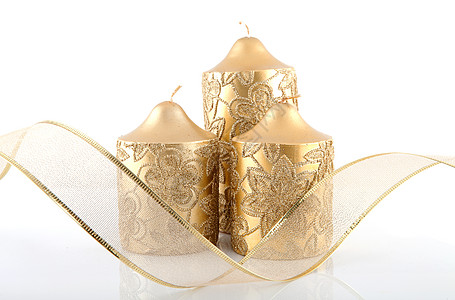 三根金蜡烛和鞠躬装饰品宗教丝带金子背景图片