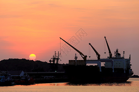 日落时货船在港口出口进口货物工作船运码头贸易商业卸载运输图片