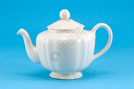 蓝色背景的旧陶瓷白茶壶盘图片