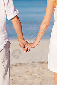 夏天 情侣在海滩上手牵手手指假期感情夫妻海洋女孩女性蓝色男性手腕背景图片