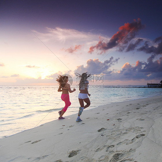 两个女人在沙滩上奔跑慢跑运动装赛跑者蓝色日落海洋天空跑步成人女性图片