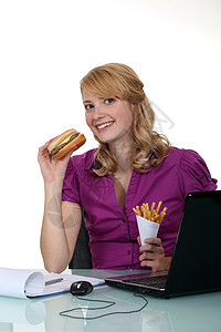 女人在办公室里吃汉堡包图片