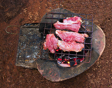 脱衣牛排新放在木炭烤炉上白色印章炙烤粉色黑色黄色食物烹饪橙子猪排图片