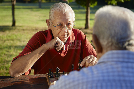 在职退休人员 两名高级男子在公园下象棋男性哥们队友专注沉思长椅朋友们祖父老年人闲暇图片