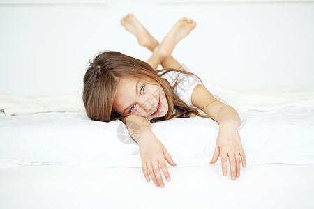 女孩在床上女儿乐趣童年毯子唤醒微笑说谎闲暇快乐头发图片