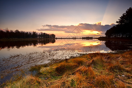 湖面的日落太阳乡村橙子荒野农村黄色戏剧性风景蓝色晴天图片