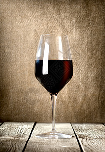 一杯红酒麻布亚麻液体帆布高脚杯木头黑色饮料酒精桌子图片