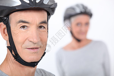 身戴自行车头盔的资深男子生活舞台保险后台老年成年人安全震惊妇女表演背景图片