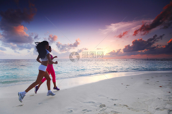 两个女人在沙滩上奔跑运动跑步蓝色女性训练海洋慢跑者慢跑运动装天空图片