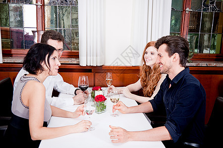 餐厅中快乐笑笑着的人们男性讲话享受闲暇团体眼镜朋友们庆典美食女性图片