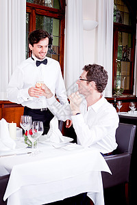 快乐的一对在餐厅笑着微笑的情侣成人眼镜酒精玻璃用餐女性生日庆典男人女士图片