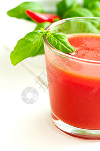 白木桌背景的番茄汁果汁叶子蔬菜液体水果红色香菜食物绿色白色图片