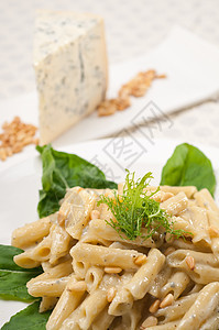 意大利通心粉戈贡佐拉和松子蓝色羊乳产品盘子松树午餐桌子菠菜干酪蔬菜图片