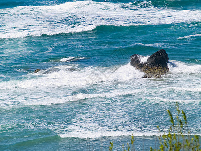在海浪撞击的海岸上支撑场景海洋全景海景岩石巨石天堂石头游客图片
