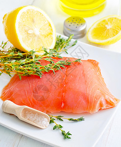 白盘上的生鲑鱼 有百香和盐石板炙烤草本植物百里香牛扒海鲜叶子柠檬宏观产品图片