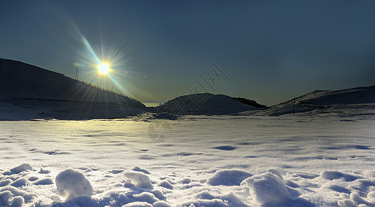 山雪背景的冬日太阳图片