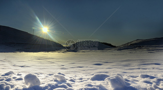 山雪背景的冬日太阳图片