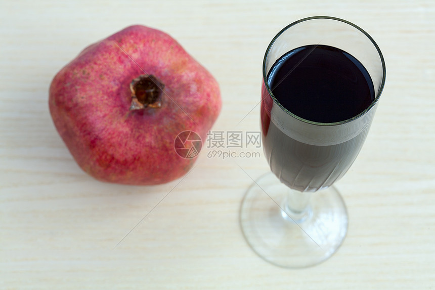 酒杯和桌上的石榴红宝石饮料庆典浆果热带食物石榴石甜点酒精玻璃图片