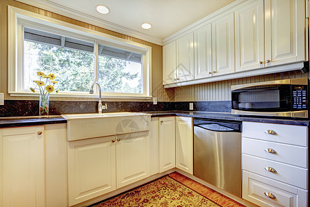 白色厨房内有大水槽和窗户房子台面橱柜天花板房地产火炉木头家电建筑学冰箱图片