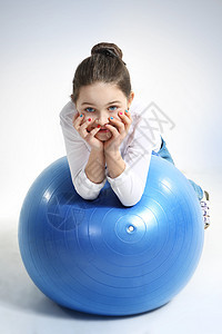 用橡皮球刺穿小女孩的肖像孩子身体微笑黑发女性体操气球蓝色橡皮牛仔裤图片