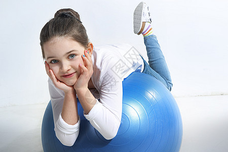 用橡皮球刺穿小女孩的肖像幸福气球运动女性牛仔裤训练精力蓝色姿势数字图片
