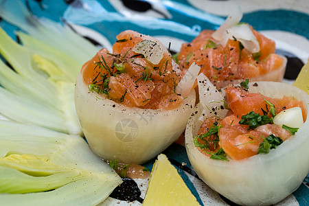 洋葱杯中的鲑鞑靼烹饪香蒜牛肉片用餐荒野鱼片柠檬食物草本植物图片