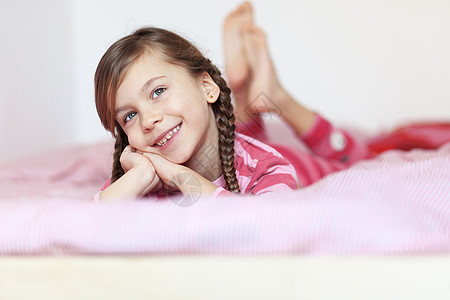 女孩在床上女儿快乐说谎乐趣情感房间寝具闲暇童年睡衣图片
