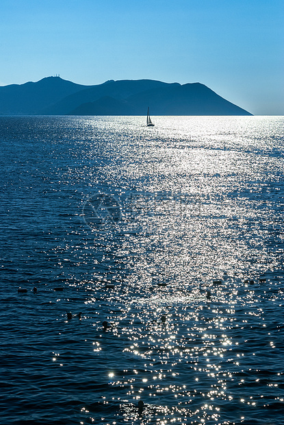 在平静的海面上游艇航行蓝色假期闲暇阳光旅行运动地平线海浪帆船工艺图片