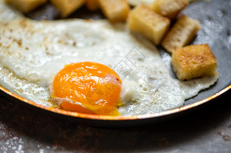 鸡蛋用面包面包粉碎垃圾油炸蛋黄金属白色烹饪平底锅背景面包块宏观图片