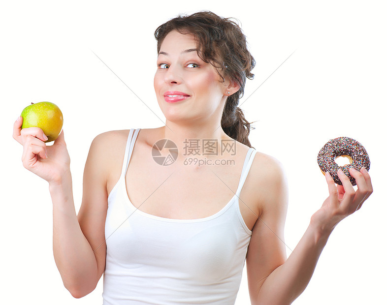美丽的年轻女子在水果和甜甜圈之间做出抉择思维食物橙子营养馅饼垃圾厨房身体女士早餐图片