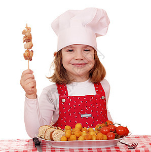 快乐的小女孩用烤鸡肉做饭图片